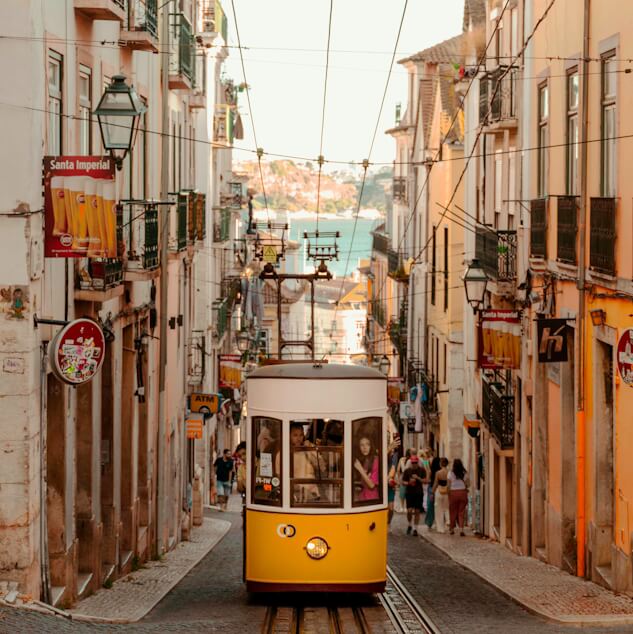 Elétrico amarelo do Elevador da Bica a subir a rua íngreme de Lisboa