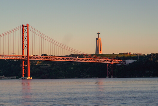 Ponte 25 de Abril e estátua do Cristo-Rei em Lisboa, com o Tejo ao fundo